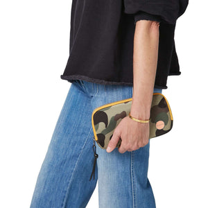 shortyLOVE jetty clutch/wallet in green camo; hand held by model in black sweatshirt and jeans against white background.