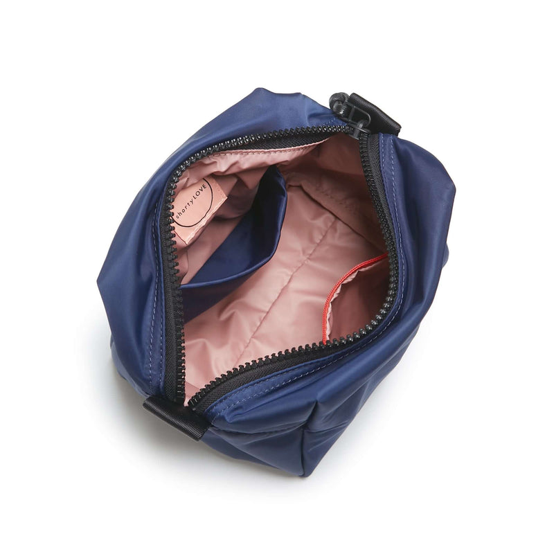 shortyLOVE stevie cosmetic bag in navy; top-down view showing interior pink lining against white background.