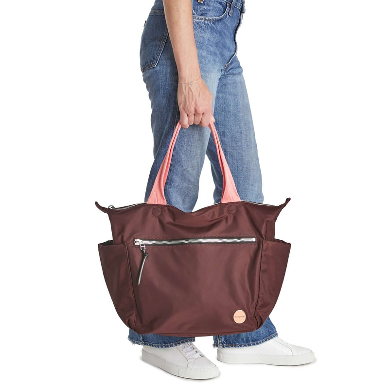 shortyLOVE tillie tote bag in burgundy; hand held by model in jeans against white background.