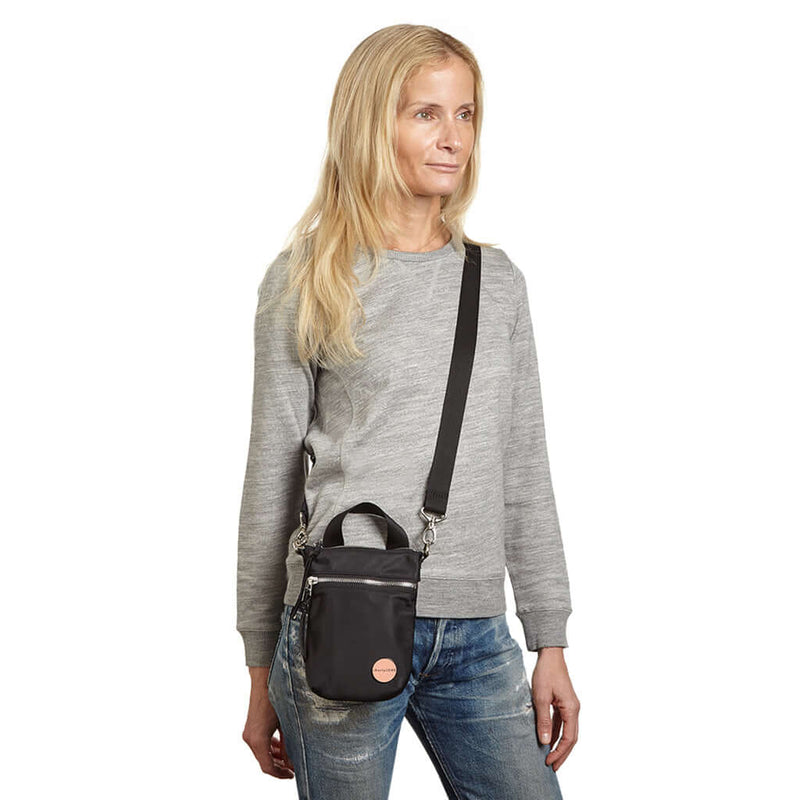 shortyLOVE shorthand crossbody phone bag in black; on model in grey sweatshirt and jeans against white background
