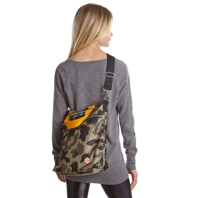 shortyLOVE wonder large crossbody/messenger bag in green camo; on model grey long sleeve sweater and black leggings against white background.