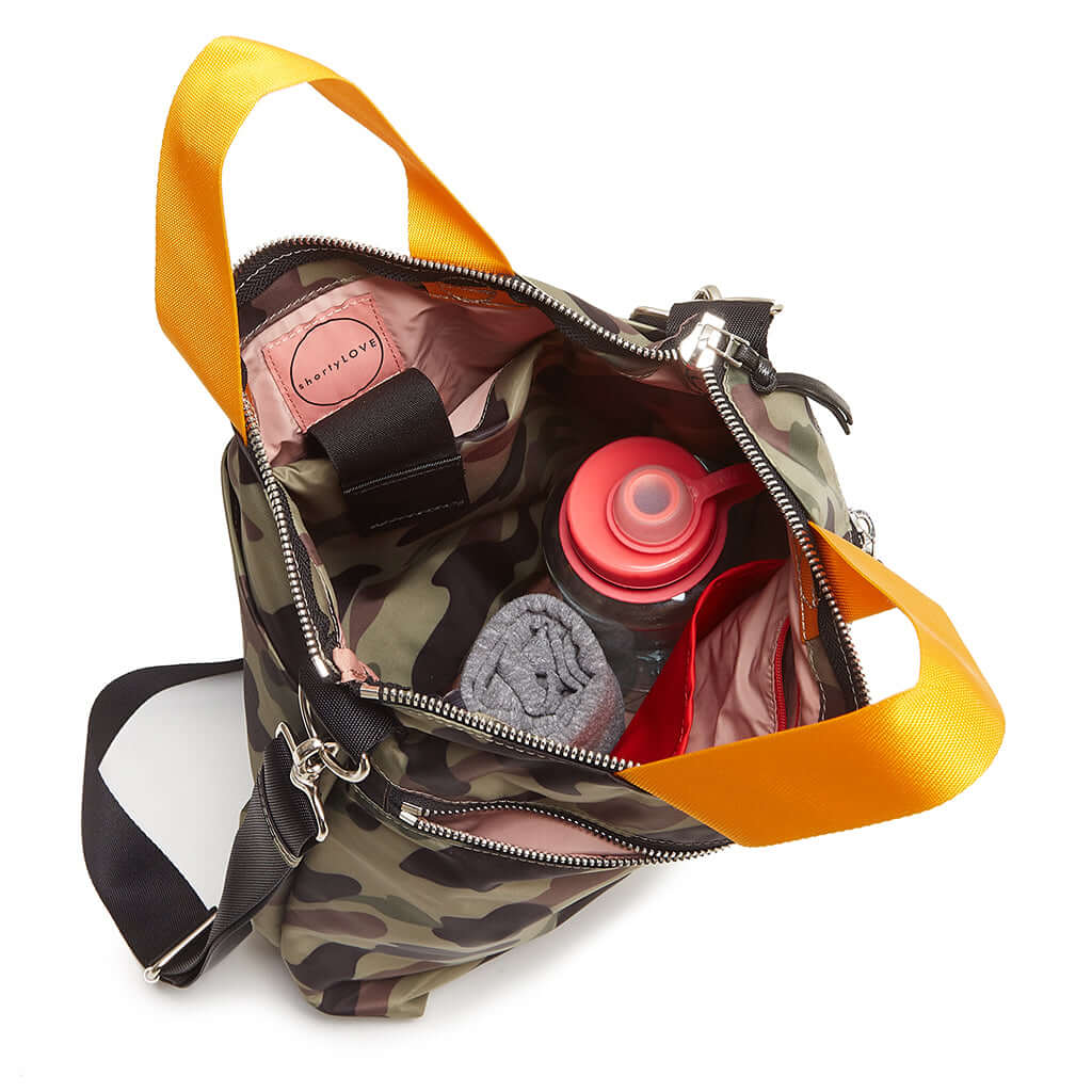 shortyLOVE wonder large crossbody/messenger bag in green camo; top-down view showing interior pink lining against white background.