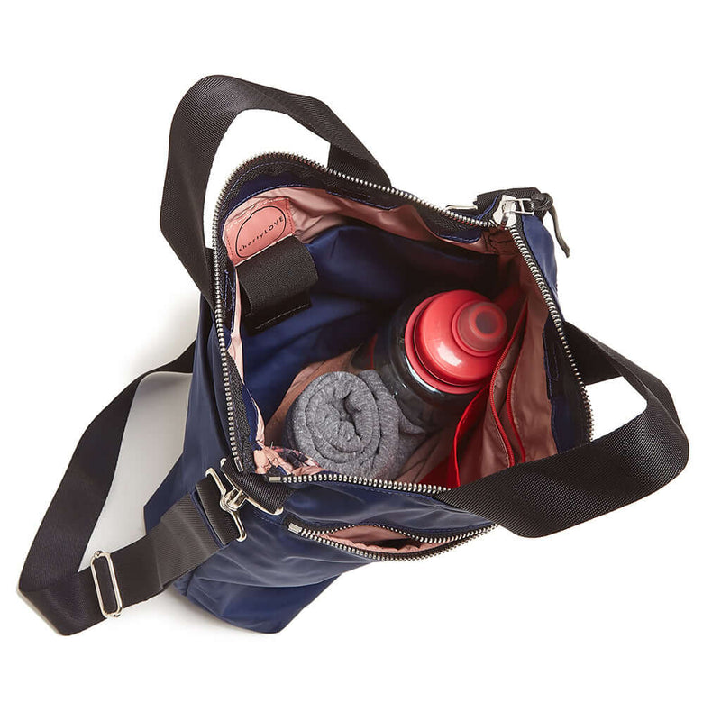 shortyLOVE wonder large crossbody/messenger bag in navy; top-down view showing interior pink lining against white background.